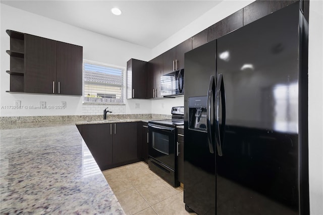 kitchen with dark brown cabinetry, sink, light stone counters, light tile patterned floors, and black appliances