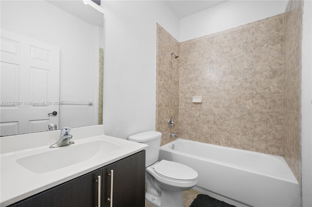 full bathroom featuring tiled shower / bath, vanity, and toilet