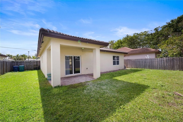 rear view of house with a patio area and a lawn