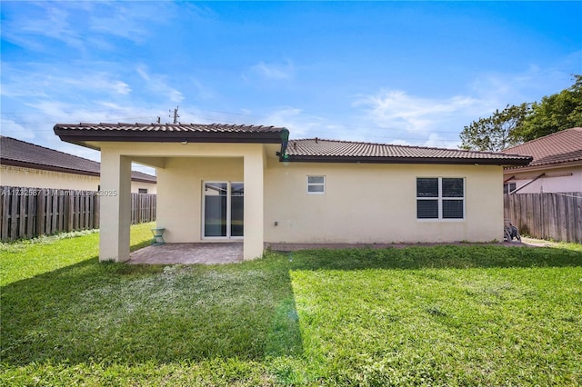 back of house featuring a lawn and a patio