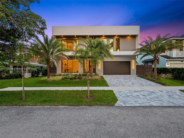 contemporary home featuring a garage and a yard