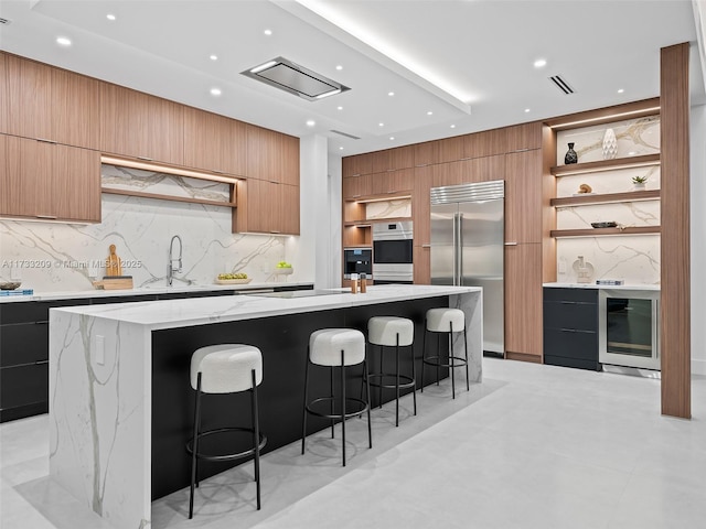 kitchen featuring a large island, wine cooler, black appliances, and a kitchen breakfast bar