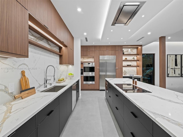 kitchen with sink, backsplash, light stone countertops, and appliances with stainless steel finishes