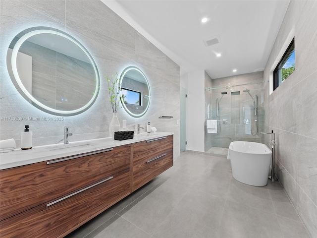 bathroom with tile walls and independent shower and bath