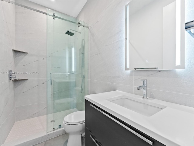 bathroom with tile walls, backsplash, vanity, an enclosed shower, and toilet