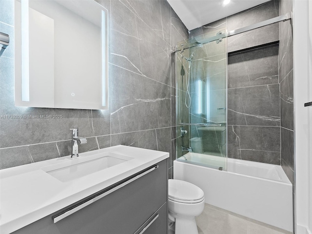 full bathroom with tile walls, bath / shower combo with glass door, tasteful backsplash, vanity, and toilet