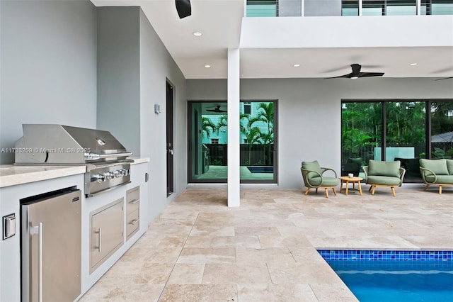 view of patio with grilling area, ceiling fan, and an outdoor kitchen