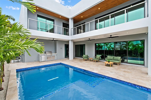 view of swimming pool featuring an outdoor hangout area, ceiling fan, a patio area, grilling area, and exterior kitchen