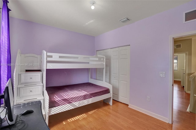 bedroom with light wood-type flooring and a closet