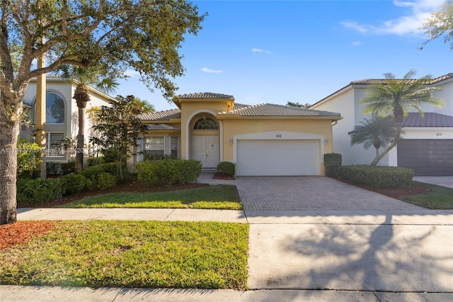 mediterranean / spanish-style home featuring a garage and a front yard