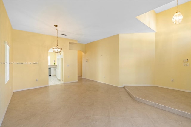 unfurnished room with a chandelier