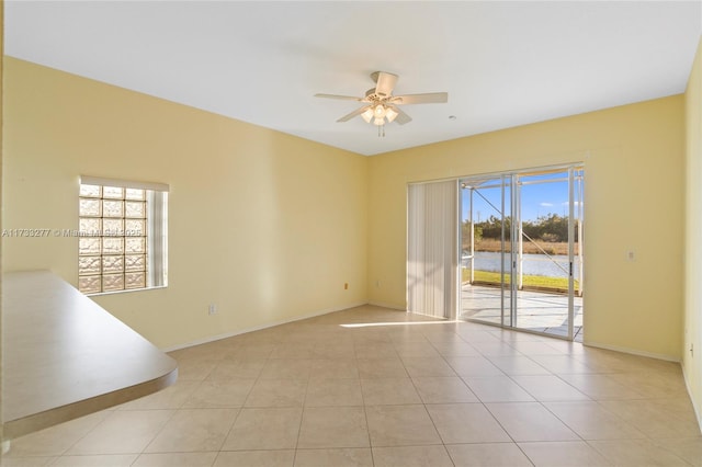 unfurnished room featuring ceiling fan, a healthy amount of sunlight, and light tile patterned floors