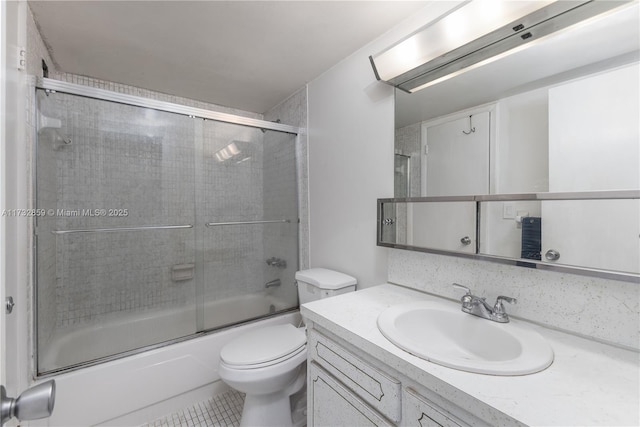 full bathroom with enclosed tub / shower combo, vanity, toilet, and tile patterned floors