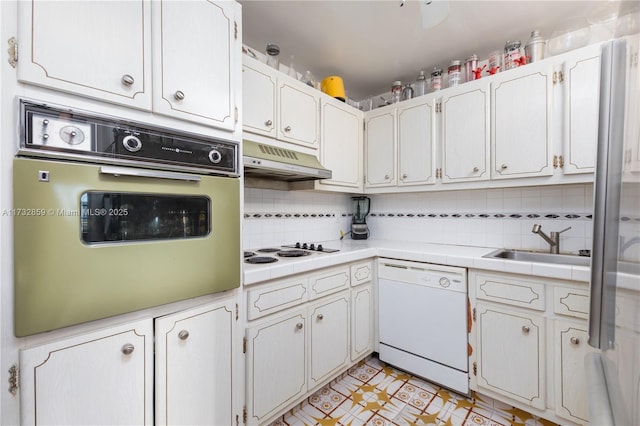 kitchen with light tile patterned floors, white appliances, white cabinetry, backsplash, and tile countertops