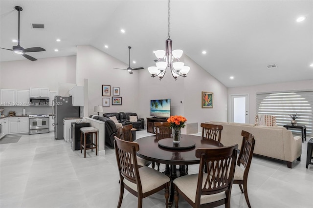 tiled dining space with ceiling fan and high vaulted ceiling