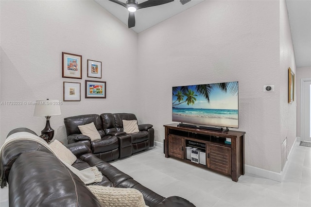 living room with ceiling fan, lofted ceiling, and light tile patterned floors