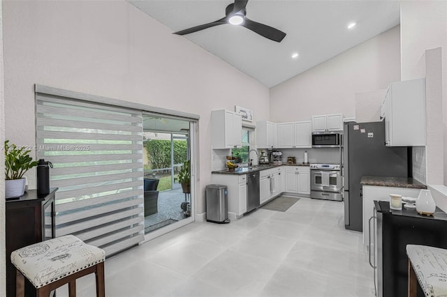 kitchen with high vaulted ceiling, sink, white cabinets, ceiling fan, and stainless steel appliances