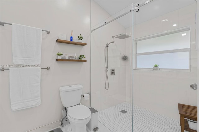 bathroom featuring toilet and tiled shower