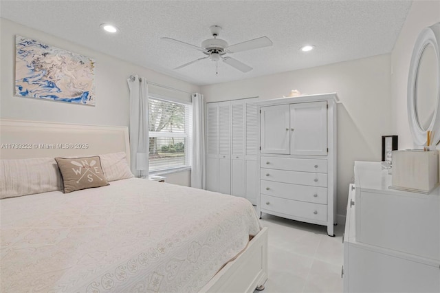 bedroom featuring light tile patterned floors, a textured ceiling, a closet, and ceiling fan