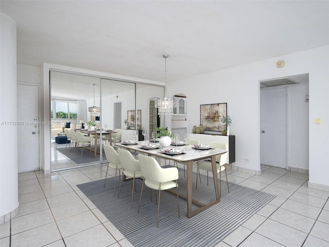 tiled dining room featuring an inviting chandelier