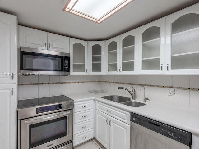 kitchen featuring sink, stainless steel appliances, white cabinets, and light tile patterned flooring