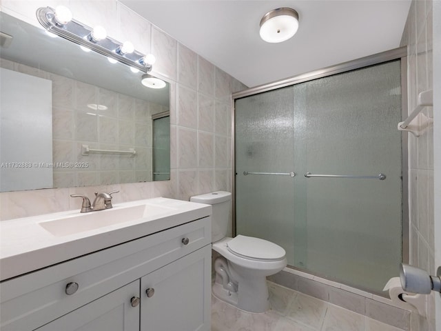 bathroom featuring tile walls, vanity, an enclosed shower, toilet, and tile patterned floors