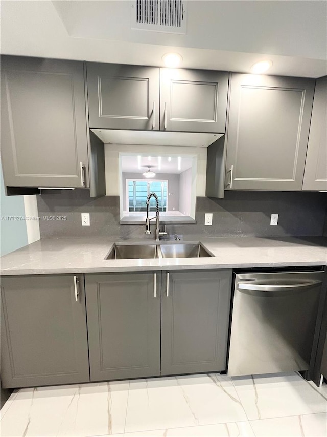 kitchen with sink, stainless steel dishwasher, backsplash, and gray cabinetry