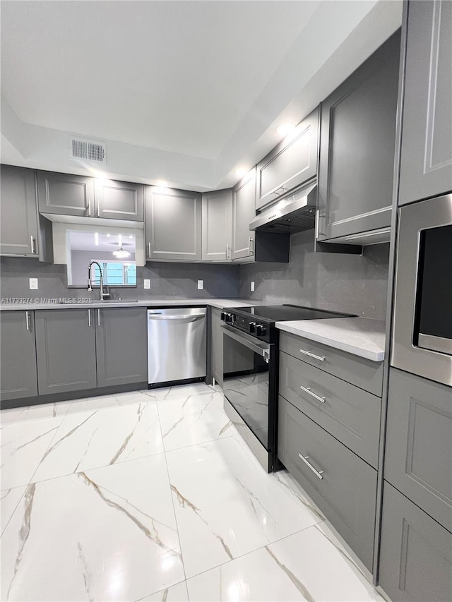 kitchen with gray cabinetry, stainless steel appliances, visible vents, and ventilation hood