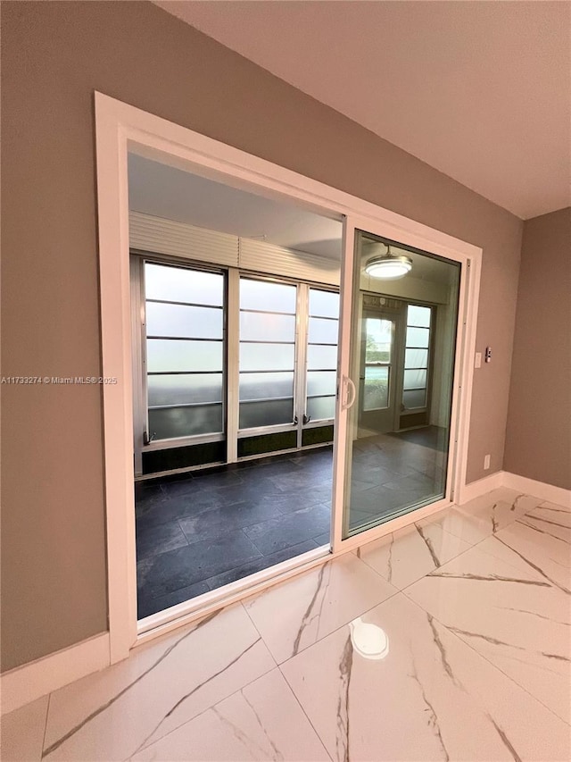 doorway featuring baseboards and marble finish floor