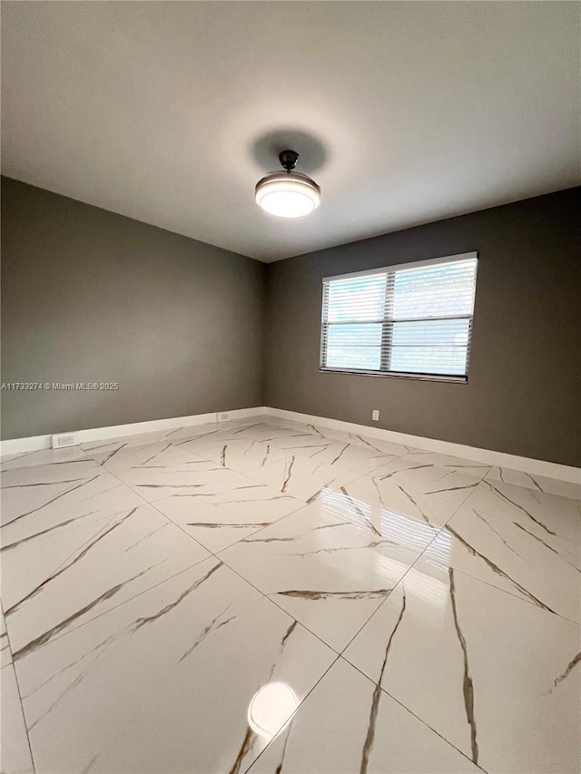 empty room with marble finish floor and baseboards