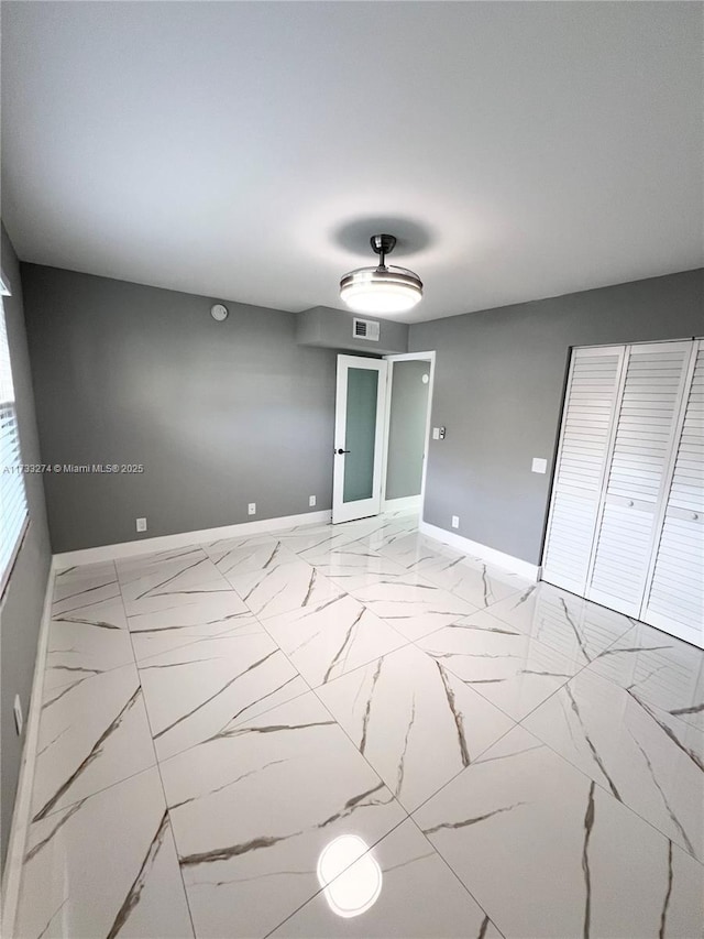 unfurnished room featuring visible vents, marble finish floor, and baseboards