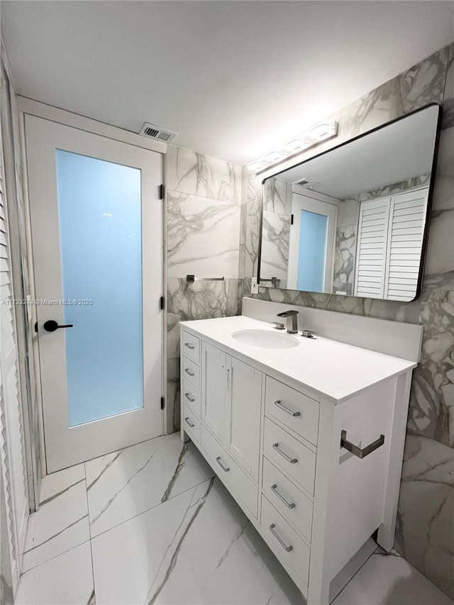 bathroom with vanity and tile walls