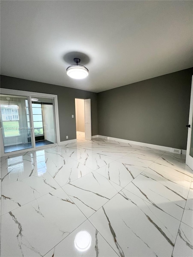 unfurnished room featuring baseboards and marble finish floor
