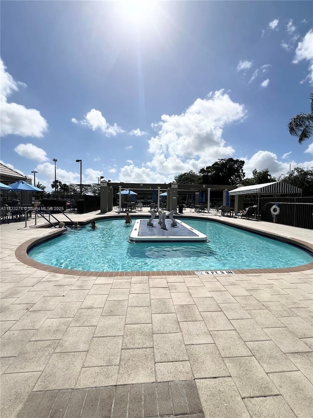 pool with a patio and fence