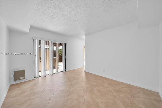 spare room featuring light tile patterned floors and a textured ceiling