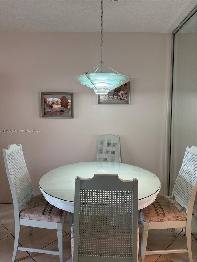 dining area with tile patterned floors and a textured ceiling