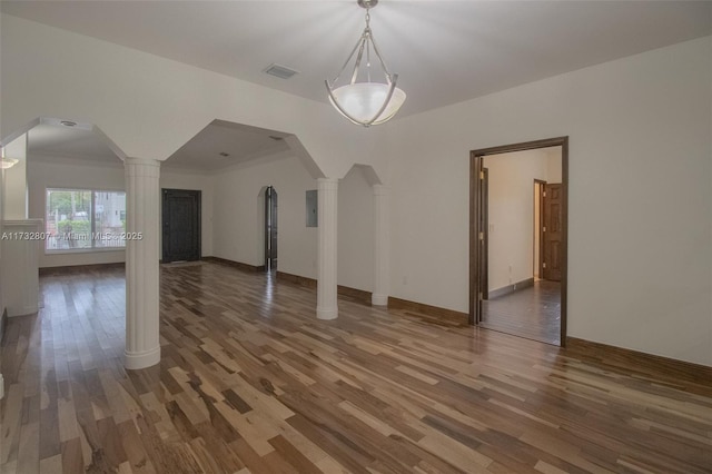 bonus room with dark wood-style floors, arched walkways, visible vents, and ornate columns