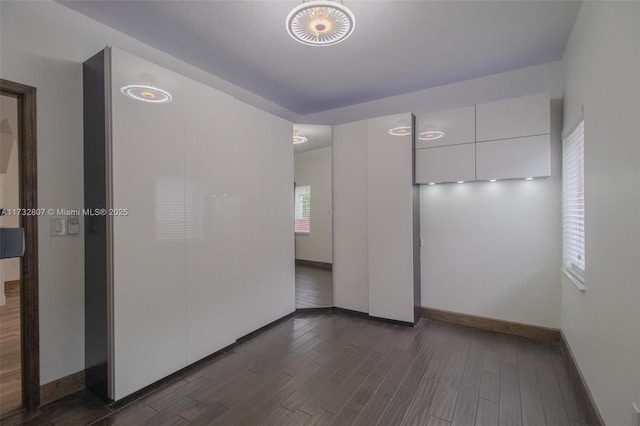 spare room with dark wood-style floors and baseboards