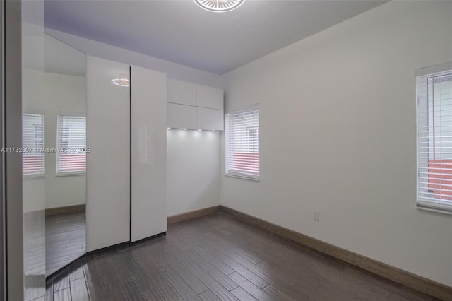 unfurnished bedroom featuring dark wood-style floors and baseboards