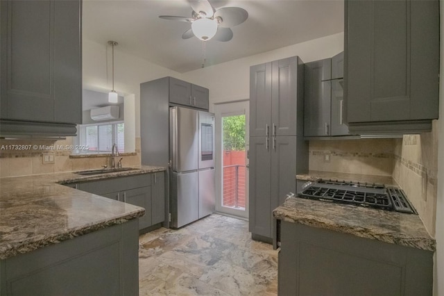 kitchen featuring appliances with stainless steel finishes, dark stone counters, a sink, and pendant lighting