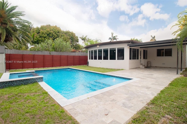 view of pool with a patio, a yard, a fenced backyard, and a pool with connected hot tub