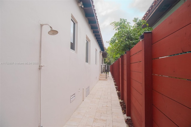 view of property exterior featuring crawl space, fence, and stucco siding