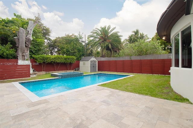 view of pool with a patio, a fenced backyard, an outdoor structure, a pool with connected hot tub, and a storage unit