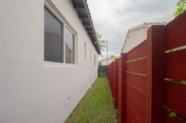 view of property exterior with crawl space, fence, a lawn, and stucco siding