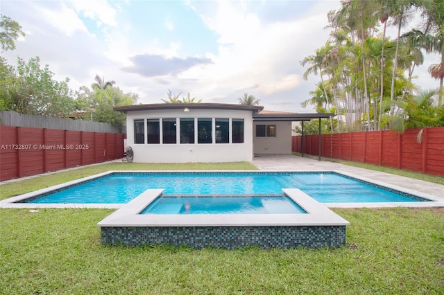 view of swimming pool with a patio area, a fenced backyard, a pool with connected hot tub, and a yard