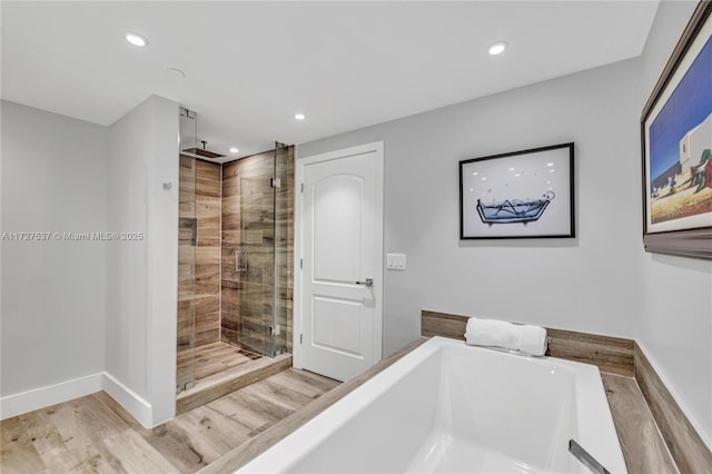 bathroom featuring hardwood / wood-style floors and plus walk in shower