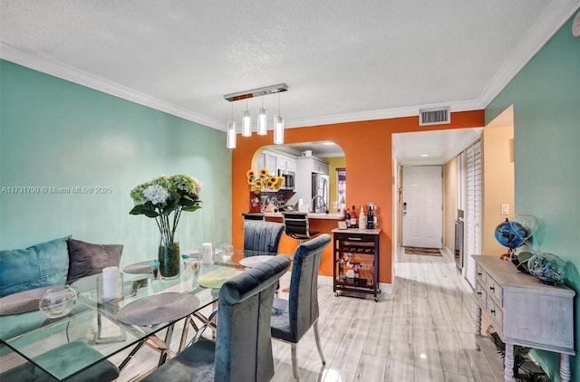 dining room with ornamental molding and a textured ceiling