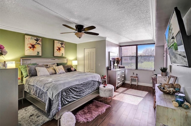 bedroom with dark hardwood / wood-style flooring, ceiling fan, crown molding, a textured ceiling, and a closet