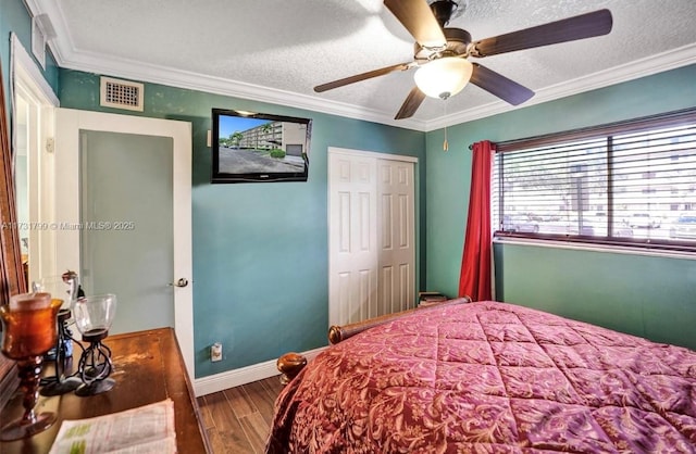 bedroom with a textured ceiling, ornamental molding, a closet, ceiling fan, and hardwood / wood-style floors