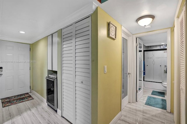 hallway with beverage cooler and light hardwood / wood-style flooring